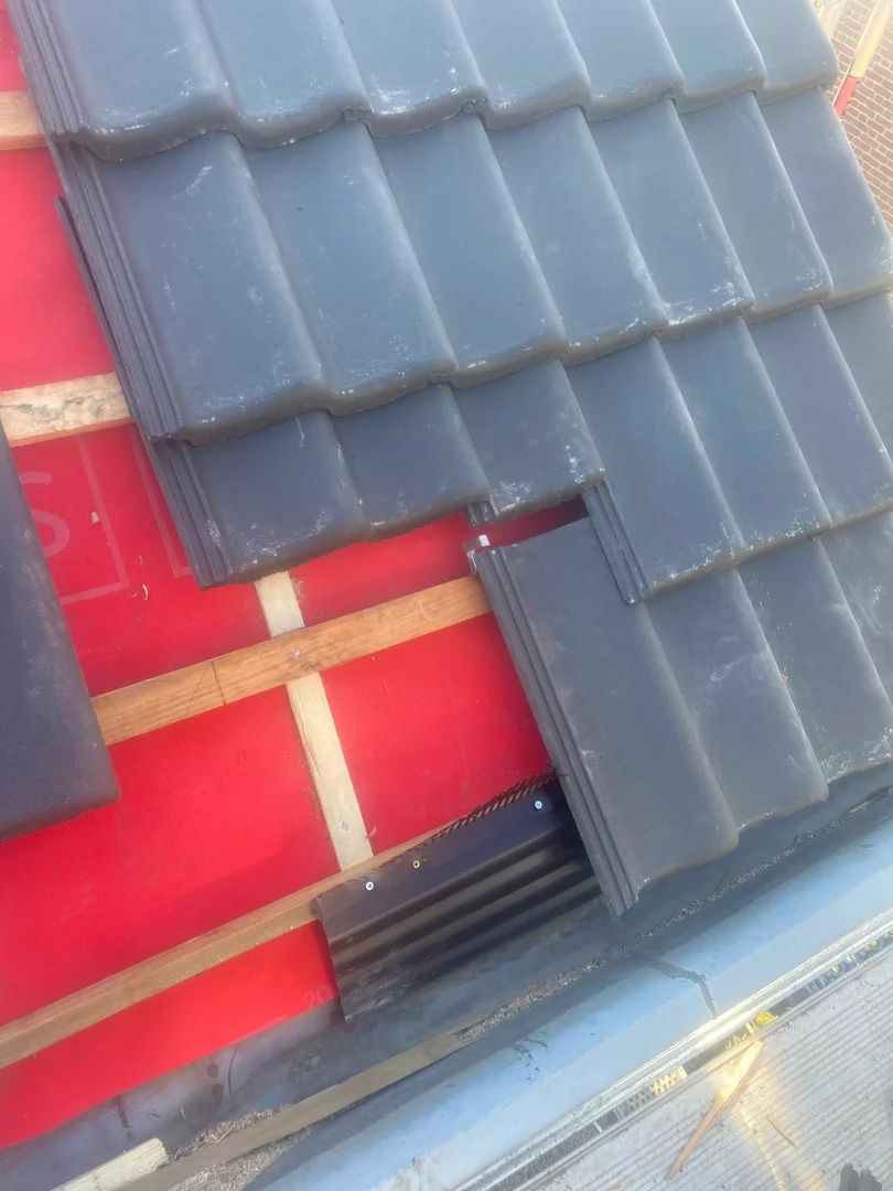 Vakman aan het werk op een hellend dak